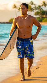 Surfer carrying a surfboard on the beach in HIC Suck Em Up 19-inch board shorts