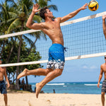 Man spiking a volleyball on the beach in HIC Digital Coast board shorts