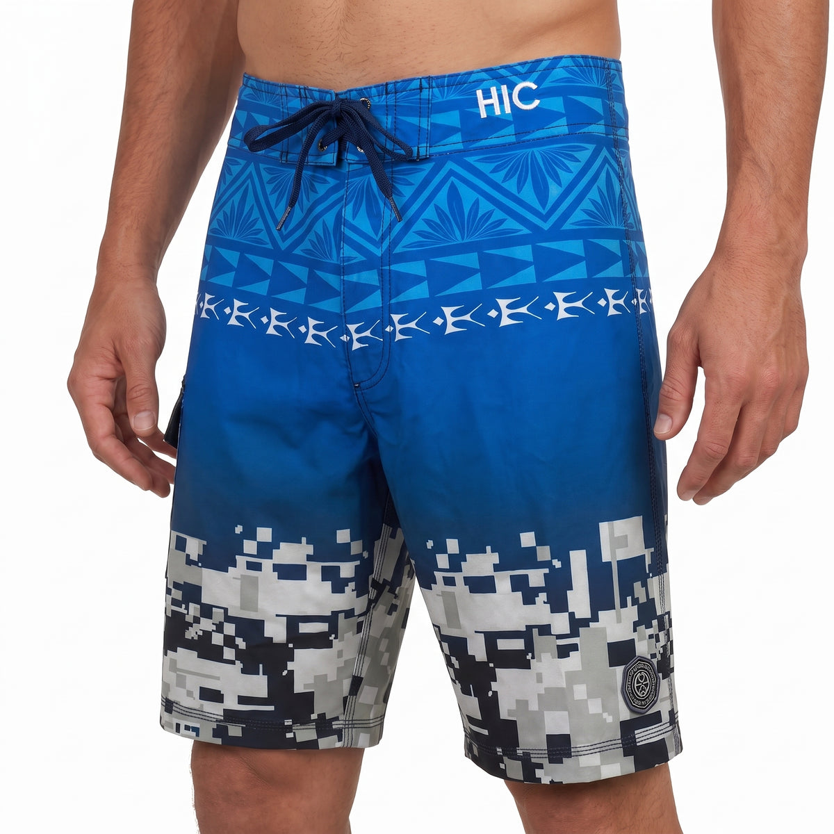 HIC Digital Coast board shorts on a model, front view of the Polynesian band and pixel print