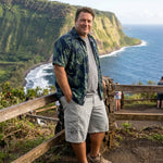 Man wearing HIC Mauna Kea men's cargo walking shorts in Stone with an aloha shirt at a Hawaii ocean lookout