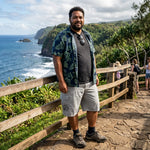 HIC Mauna Kea men's cargo walking shorts in Stone with hiking shoes on a Hawaii coastal path