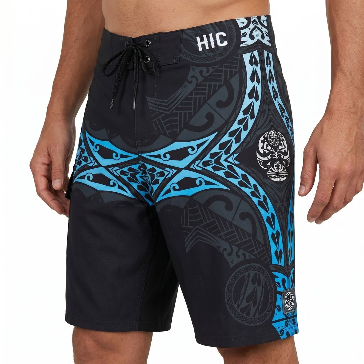 HIC Kanaha board shorts up close: blue Polynesian band over a charcoal print